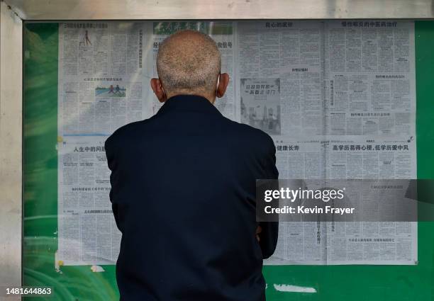 Man reads a newspaper posted outside on a street on April 12, 2023 in Beijing, China. While the majority of people in China read their news via the...