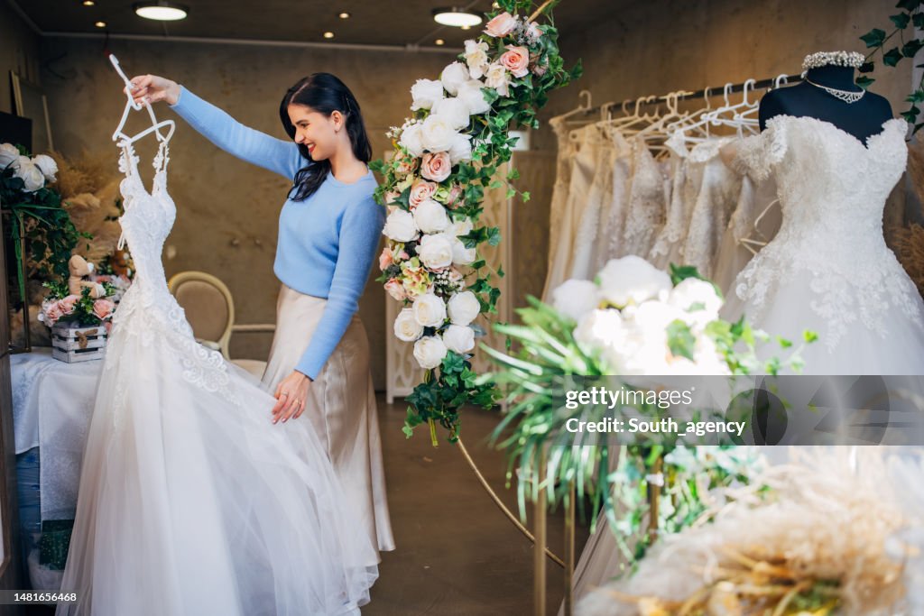 Bride to be looking at the wedding dresses at the bridal shop