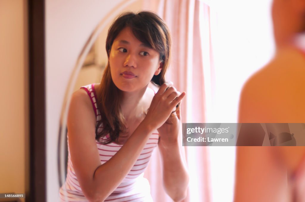 Young woman dresses her hair