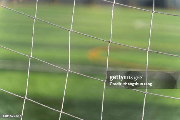 empty green grass soccer field against white goal net - trainingsgelände stock-fotos und bilder