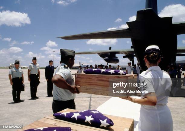 Simple wooden boxes containing the remains of United States soldiers and airmen missing in action during the Vietnam War are carried aboard an...