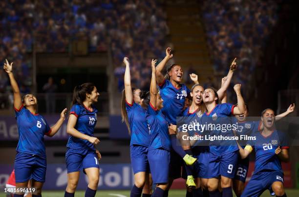 a team of female soccer players joyously react to a play during a sports competition. - competición de fútbol fotografías e imágenes de stock