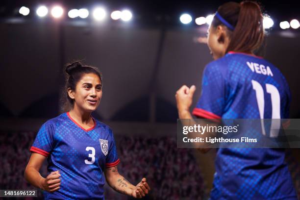 two women walk toward each other after a proud moment during a soccer game. - prop sporting position stock pictures, royalty-free photos & images