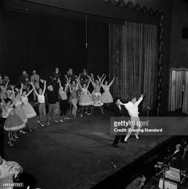 Singers Cliff Richard and Adam Faith with cast members and musicians on stage during rehearsals for a Royal Command Performance variety show,...