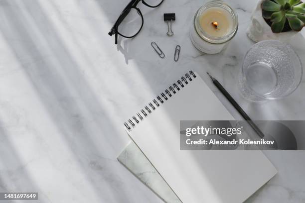 woman workplace business background. flat lay with office and education accessories - notepad, glasses, glass of water, candle and succulent plant. high angle view, copy space. mock up concept - pen table stock pictures, royalty-free photos & images