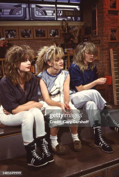 View of, from left, Pop singers Keren Woodward, Siobhan Fahey, and Sara Dallin, all of the group Bananarama, as they all sit on a low stage during an...