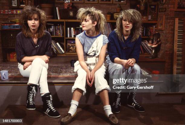 View of, from left, Pop singers Keren Woodward, Siobhan Fahey, and Sara Dallin, all of the group Bananarama, as they all sit on a low stage during an...