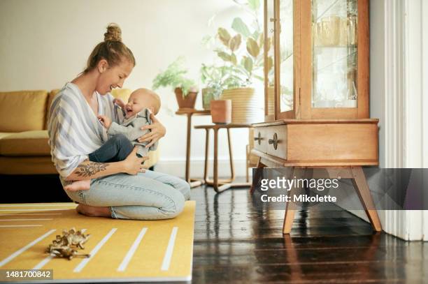 mother smile, baby and play in home living room, bonding and having fun together. development, happiness and mama holding child, kid or newborn, playing and care while enjoying quality time in house. - kind person stock pictures, royalty-free photos & images