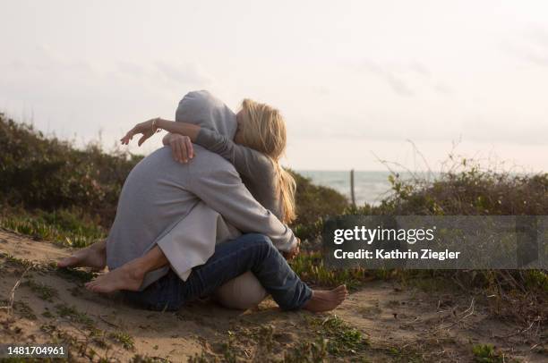 couple hugging and kissing on the beach - couple dunes stock pictures, royalty-free photos & images