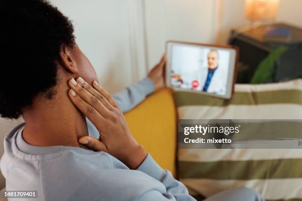 over the shoulder view of young woman checking lymph node over video call - hypothyroidism stock pictures, royalty-free photos & images