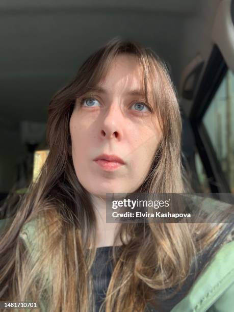 selfie of a blue-eyed girl with brown hair in the car, close-up. - bad bangs imagens e fotografias de stock