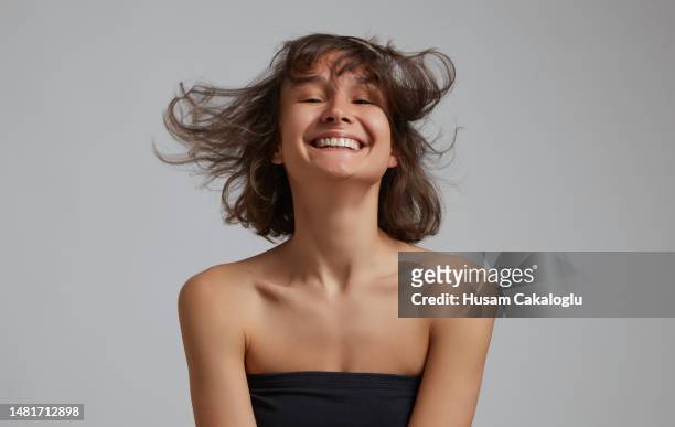 portrait d’une jeune femme souriante aux cheveux volants. - cheveux au vent photos et images de collection