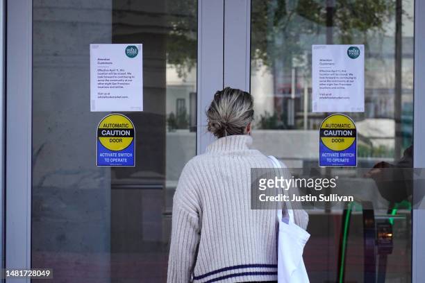 Customer stops to read a sign posted on the front door of a closed Whole Foods store on April 12, 2023 in San Francisco, California. Whole Foods has...