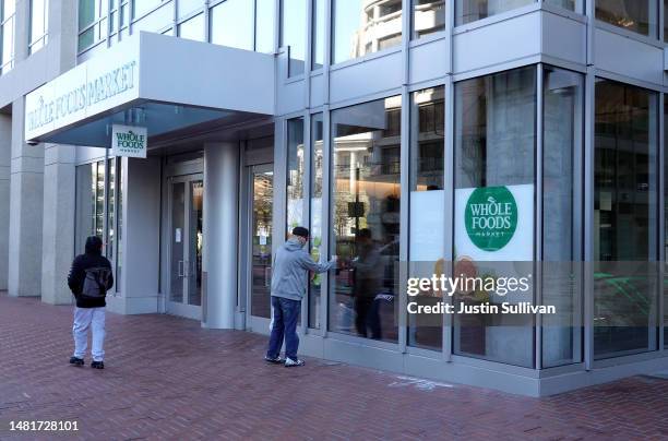 Pedestrian looks in a window at a closed Whole Foods store on April 12, 2023 in San Francisco, California. Whole Foods has temporarily closed one of...