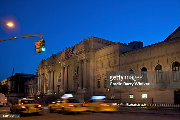 moving taxis and cultural attraction at dusk - metropolitan museum of art new york city stock-fotos und bilder