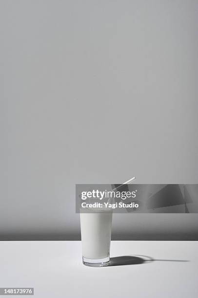 the milk which a glass contains on white backgroun - glass of milk stock pictures, royalty-free photos & images