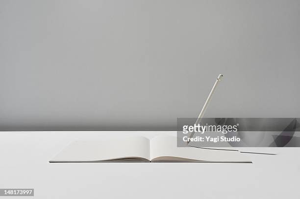 notebook and pencil on white background - 初めて ストックフォトと画像