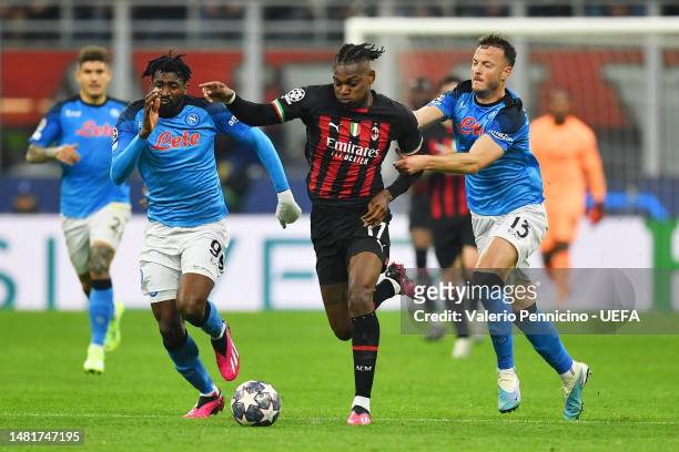 Rafael Leao of AC Milan dribbles with the ball under pressure from Andre-Frank Zambo Anguissa and Amir Rrahmani of SSC Napoli during the UEFA...