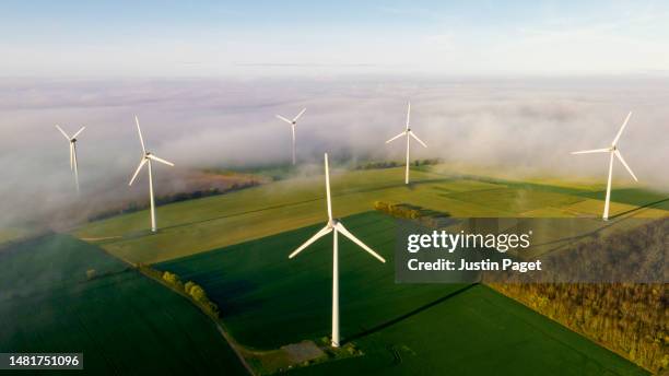 aerial view of wind turbines on a misty morning - aerogenerador fotografías e imágenes de stock