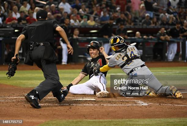 Jake McCarthy of the Arizona Diamondbacks is tagged out at home plate by William Contreras of the Milwaukee Brewers during the third inning at Chase...