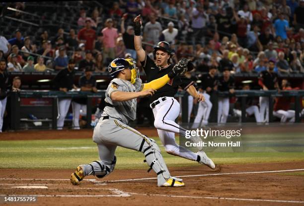 Jake McCarthy of the Arizona Diamondbacks is tagged out at home plate by William Contreras of the Milwaukee Brewers during the third inning at Chase...