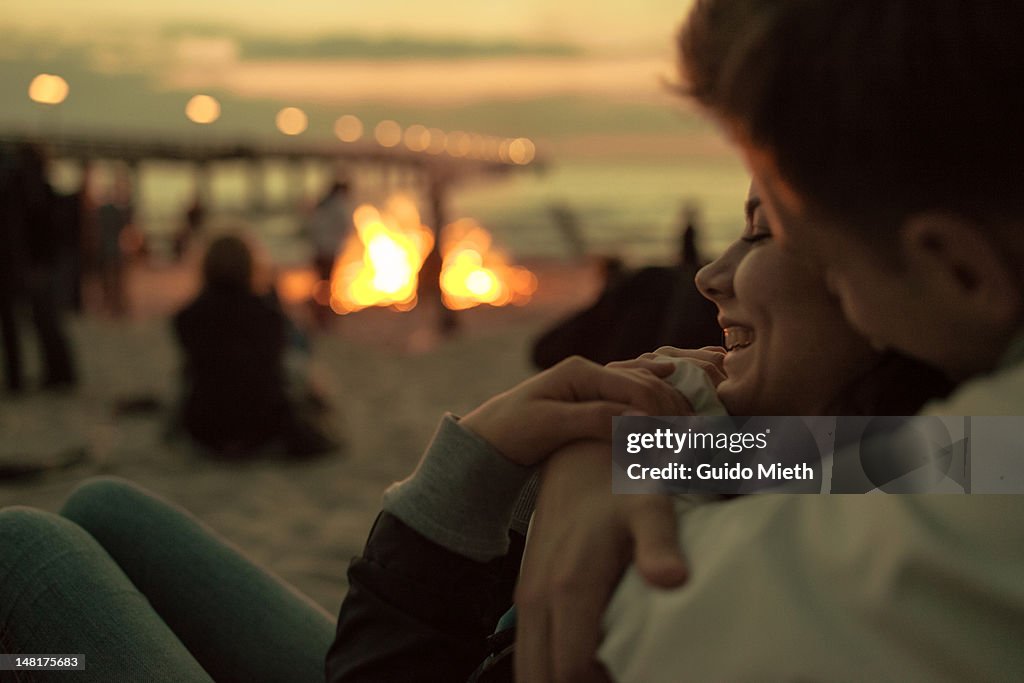Young couple hugging at campfire