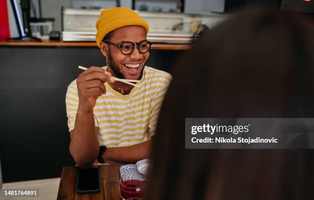 dinner party with friends eating sushi - sushi chopsticks stock pictures, royalty-free photos & images