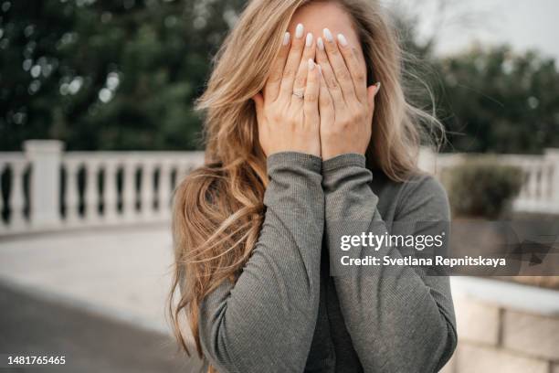 girl covered her face with her hands emotional stress - awkward stock pictures, royalty-free photos & images