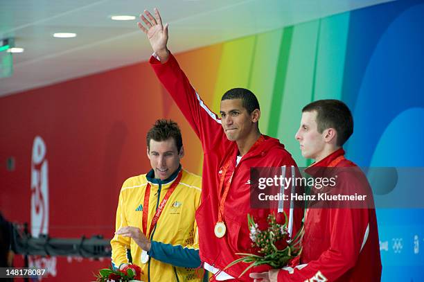 Summer Olympics: Australia Grant Hackett with silver medal, Tunisia Oussama Mellouli victorious with gold medal, and Canada Ryan Cochrane with bronze...