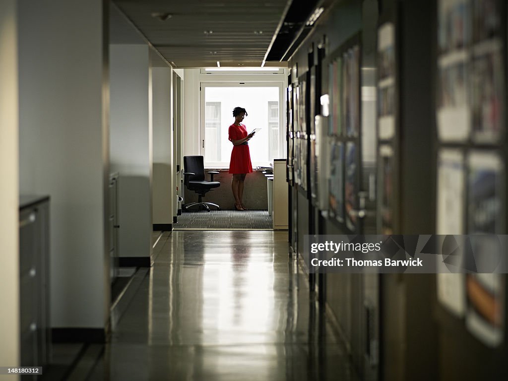 Businesswoman in office looking at digital tablet