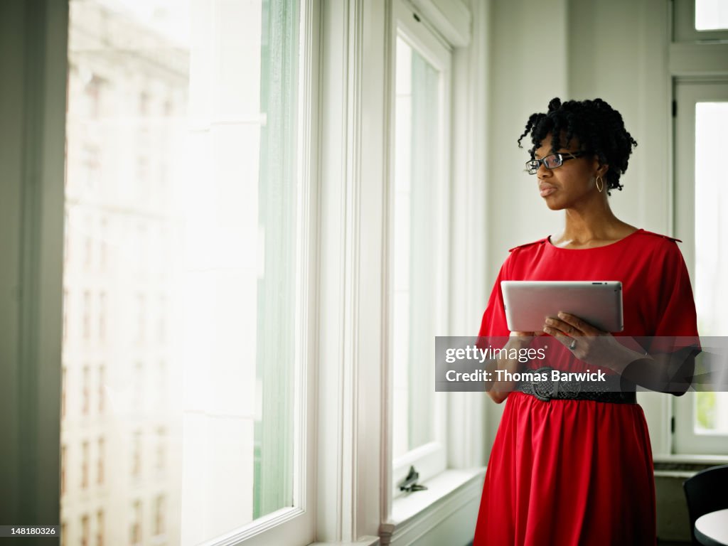 Businesswoman in office holding digital tablet