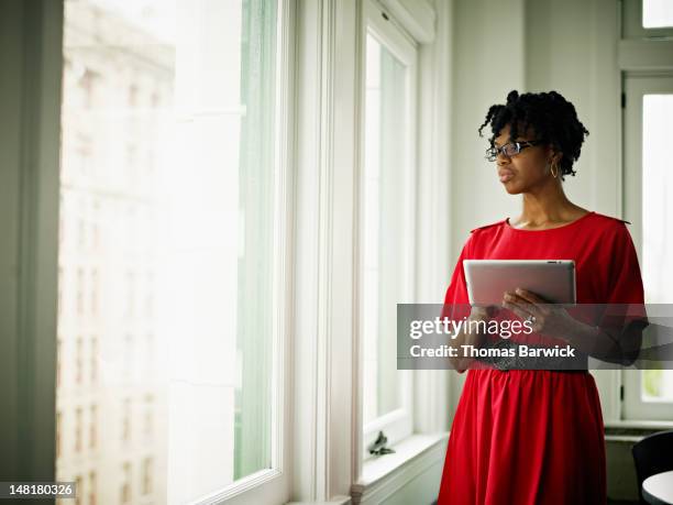 businesswoman in office holding digital tablet - one person in focus stock pictures, royalty-free photos & images