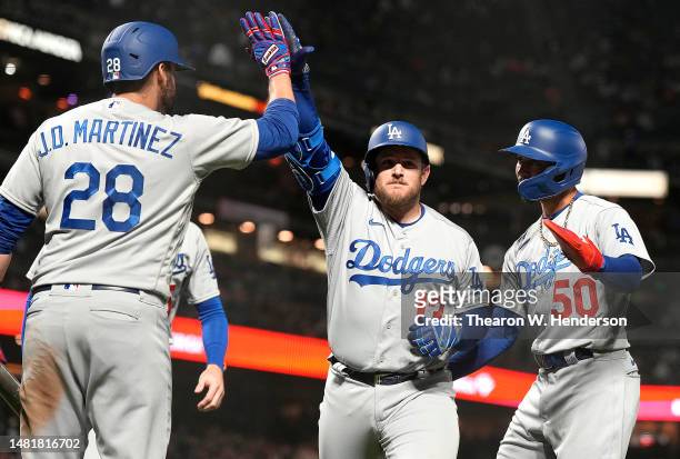 Max Muncy of the Los Angeles Dodgers is congratulated by J.D. Martinez and Mookie Betts after Muncy hit a three-run home run against the San...