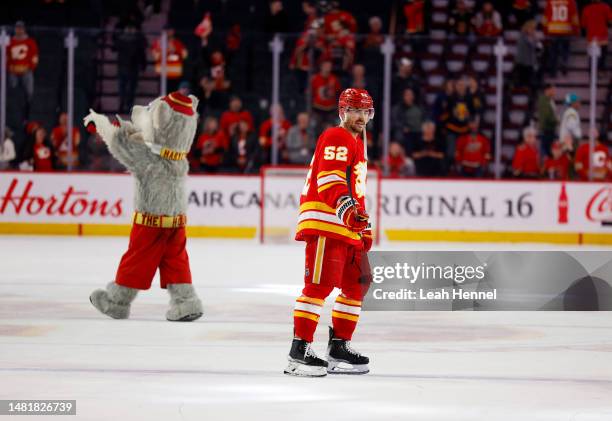 MacKenzie Weegar of the Calgary Flames and Flames mascot Harvey the Hound akcnowledge the crowd after a 3-1 win against the San Jose Sharks at the...