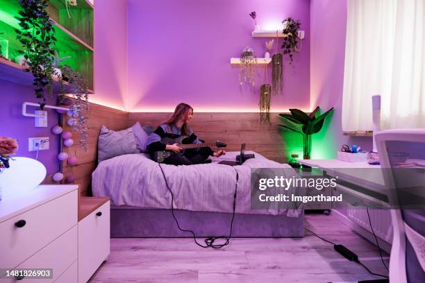 teenager spielt e-gitarre in ihrem zimmer - girls modern room stock-fotos und bilder