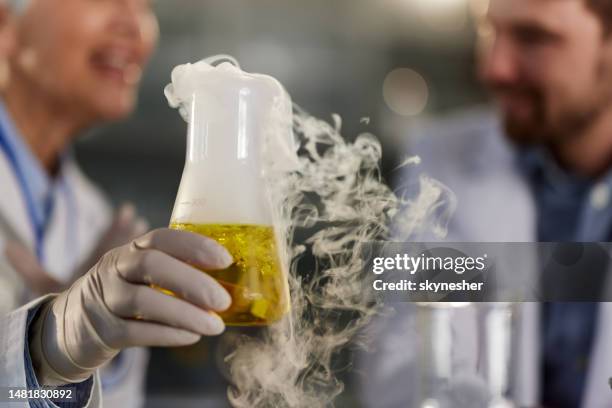 examining chemical reaction of yellow liquid in laboratory. - volume fluid capacity stock pictures, royalty-free photos & images