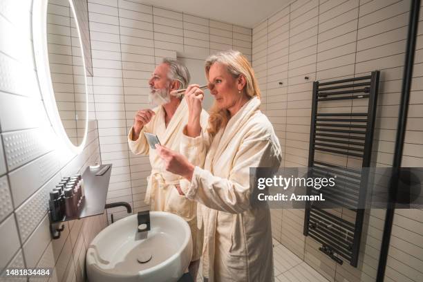 mature caucasian couple starting a day in a domestic bathroom - pick tooth bildbanksfoton och bilder