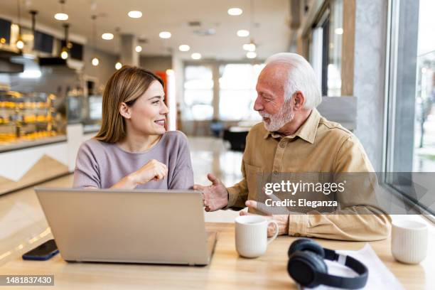 two business people having business meeting at coffee shop - workplace relations stock pictures, royalty-free photos & images