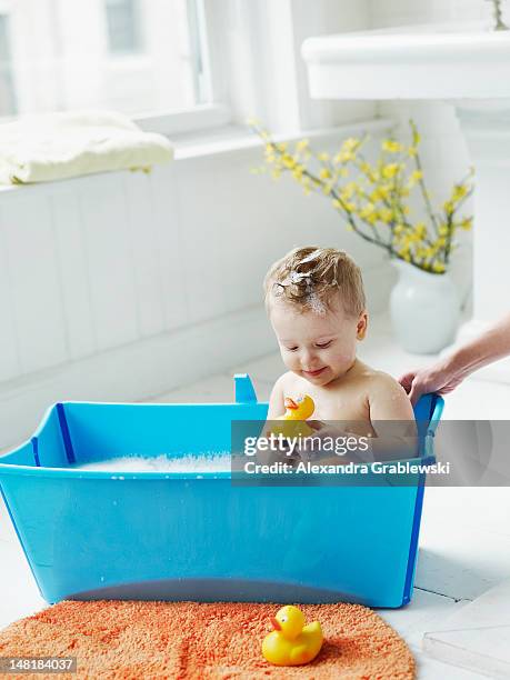 boy in tub with duckie - baby bath toys stock pictures, royalty-free photos & images