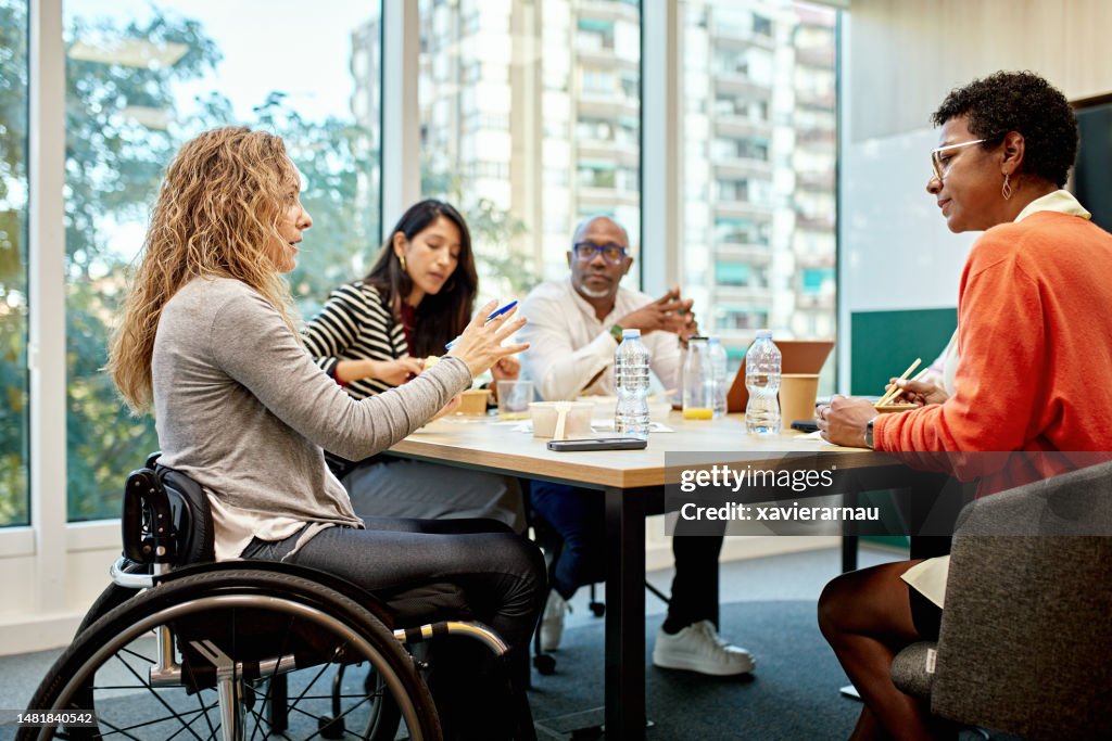 Des collègues des années 20 et 40 conversant dans une salle de réunion