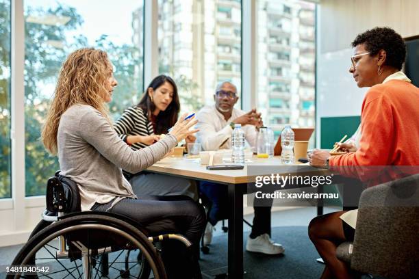 coworkers in 20s and 40s conversing in meeting room - accessibility stock pictures, royalty-free photos & images