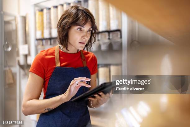 woman working in a zero waste store taking inventory - obter inventário imagens e fotografias de stock