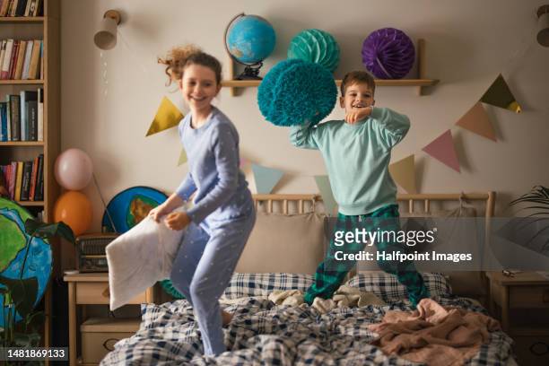 children playing on bed with pillow, having fun. - kissenschlacht stock-fotos und bilder