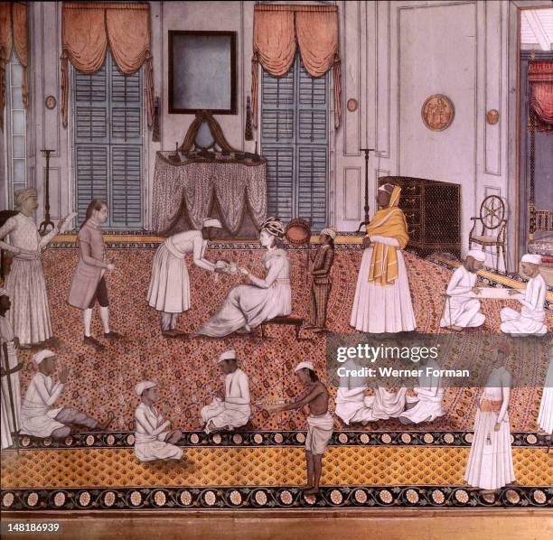An Indian miniature showing the wife of a British officer attended by numerous servants, The setting is a European style house interior, mixing...