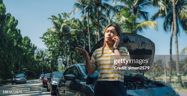 stuck on the side of the road: a young asian woman's experience with car trouble - auto insurance stock pictures, royalty-free photos & images