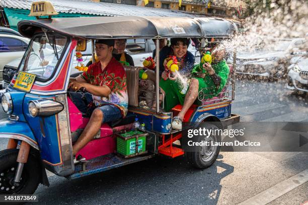 Tourists spray water guns out of a tuk tuk on Khaosan Road during the Songkran festival on April 13, 2023 in Bangkok, Thailand. Songkran, the...