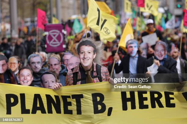 Activists from the environmental action and human rights group Extinction Rebellion march dressed as billionaires, including Facebook head Mark...