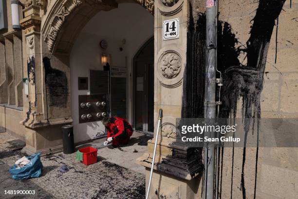 Worker cleans up after activists from the environmental action and human rights group Extinction Rebellion defaced the entrance to the headquarters...