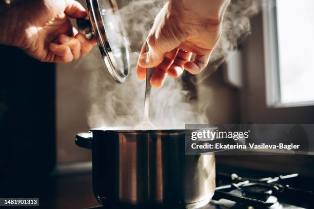 man cooking in the kitchen - pan keukengereedschap stockfoto's en -beelden