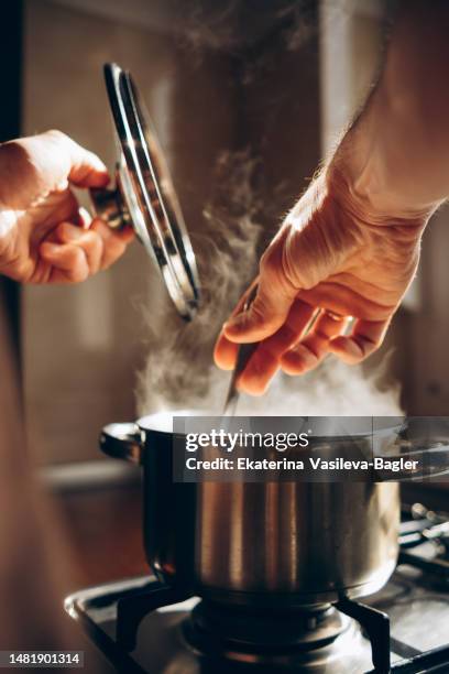 man cooking in the kitchen - soup home foto e immagini stock